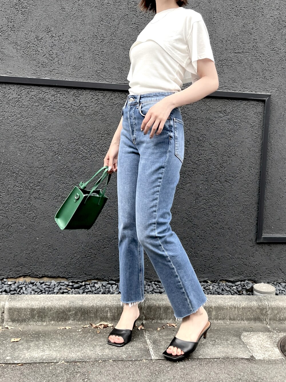 ブルー系のデニムパンツ、ホワイト系のTシャツ/カットソー、グリーン系のショルダーバッグを着用したレディースの夏コーディネートの2枚目の写真