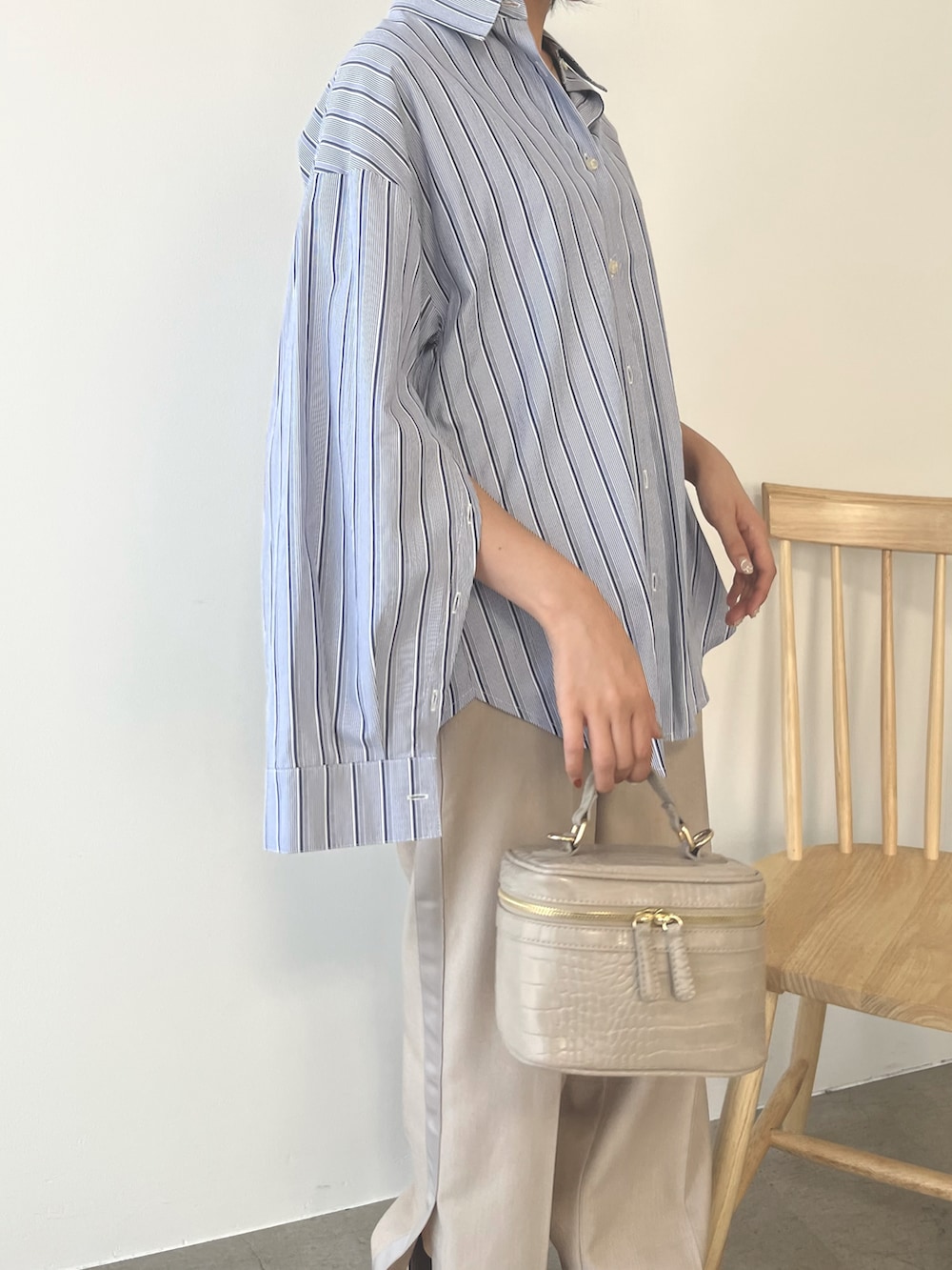 ベージュ系のハンドバッグ、ブルー系のシャツ/ブラウス、ベージュ系のパンツを着用したレディースの秋コーディネートの2枚目の写真