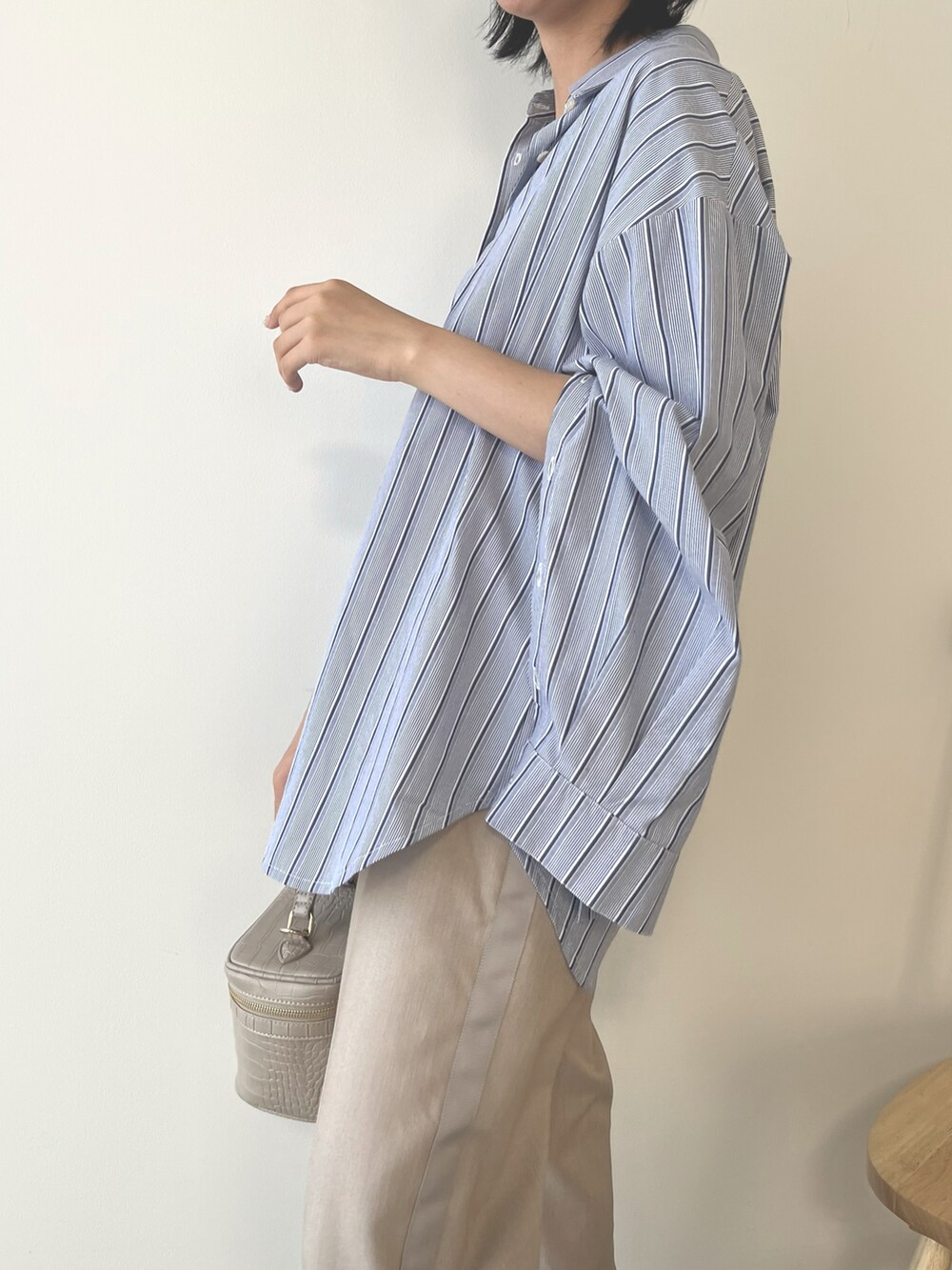 ベージュ系のハンドバッグ、ブルー系のシャツ/ブラウス、ベージュ系のパンツを着用したレディースの秋コーディネートの4枚目の写真