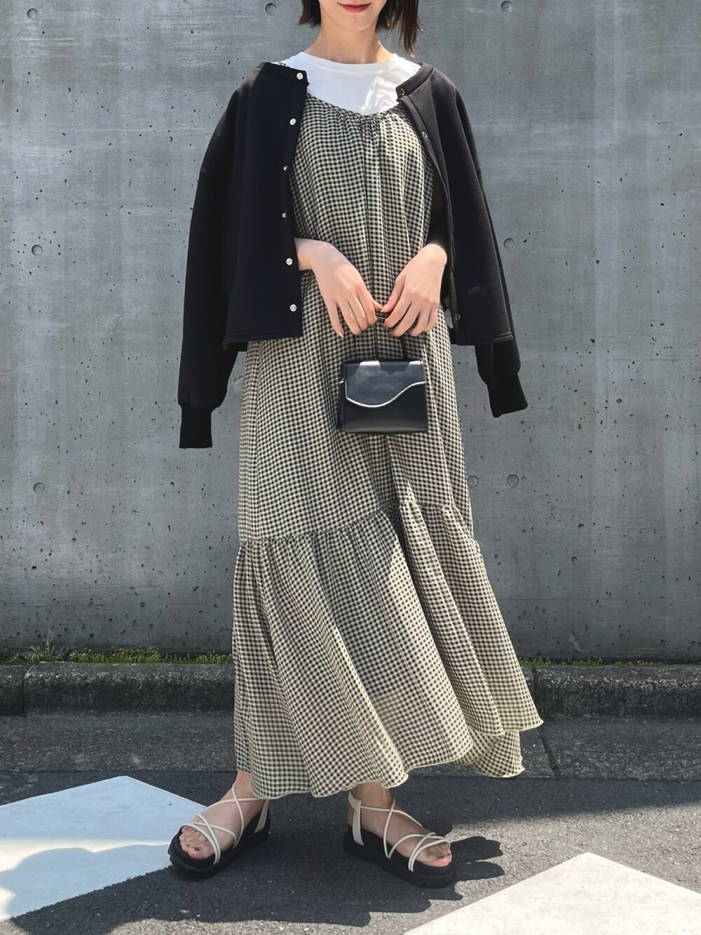 ホワイト系のサンダル、イエロー系のワンピース、ブラック系のカーディガン/ボレロを着用したレディースの春コーディネートの4枚目の写真