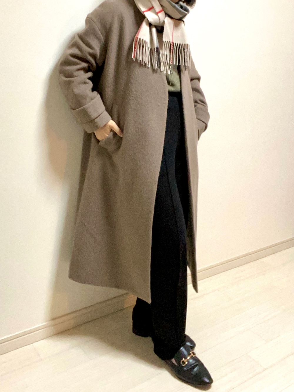 ブラック系のスウェットパンツ、ブラック系のローファー、グリーン系のニット/セーターを着用したレディースの冬コーディネートの2枚目の写真