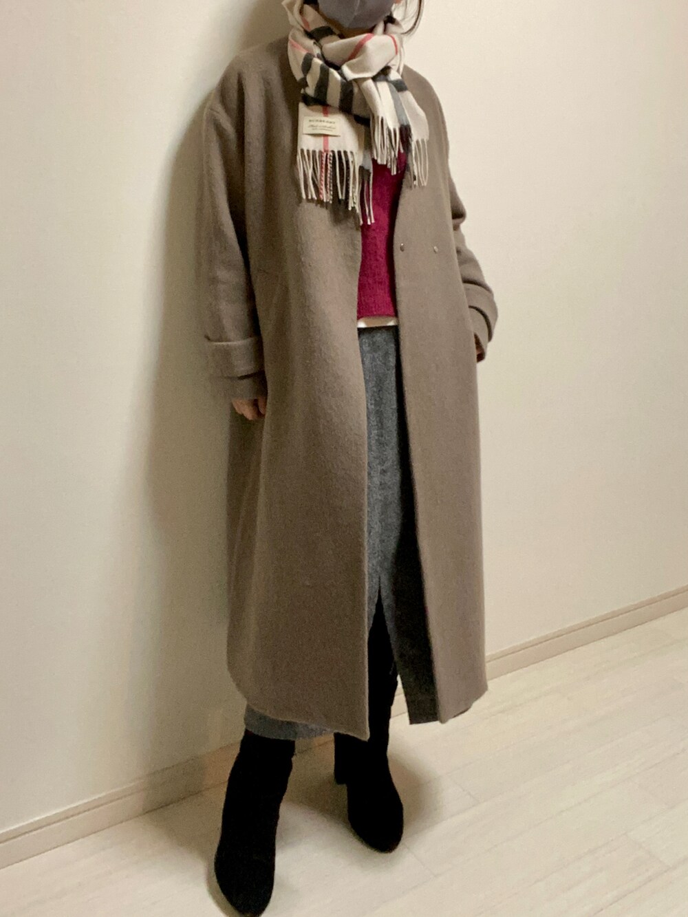 グレー系のスカート、ブラック系のブーツ、ピンク系のニット/セーターを着用したレディースの冬コーディネートの2枚目の写真