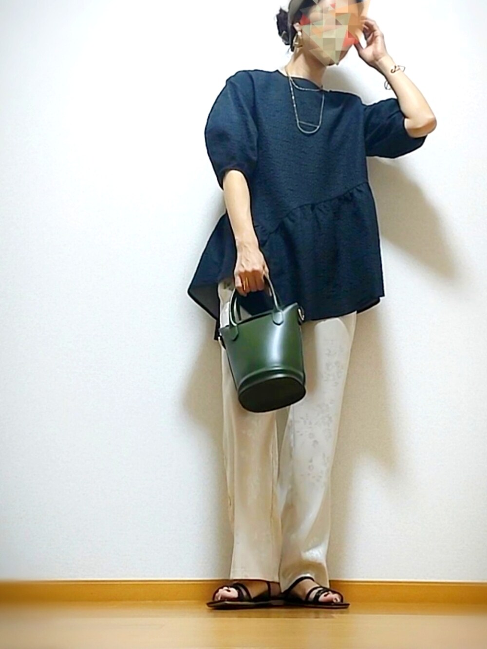 ブラック系のショルダーバッグ、ホワイト系のパンツ、ブラック系のトップスを着用したレディースの夏コーディネートの2枚目の写真