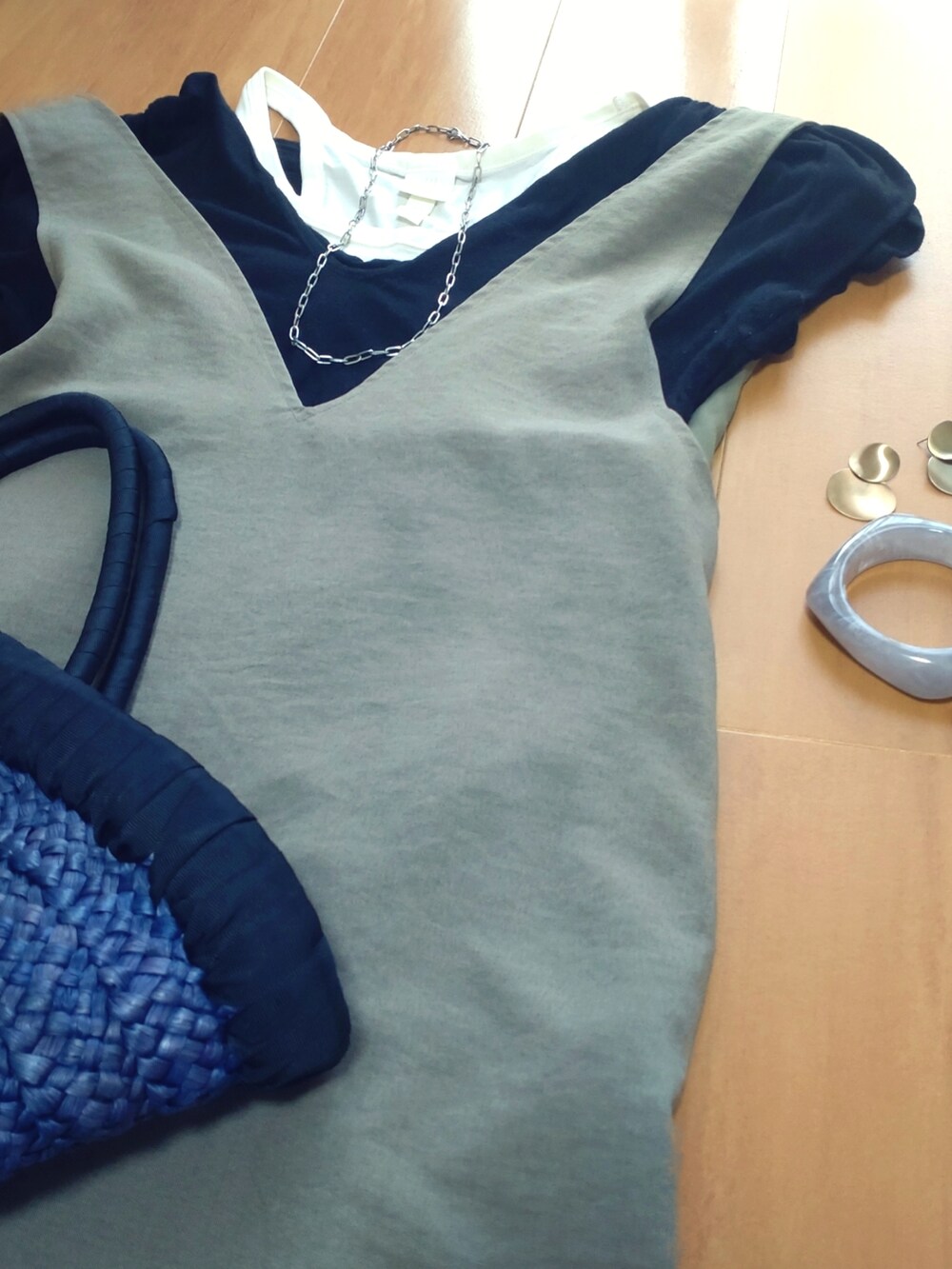 ブルー系のかごバッグ、グリーン系のワンピース、ブラック系のTシャツ/カットソーを着用したレディースの夏コーディネートの2枚目の写真