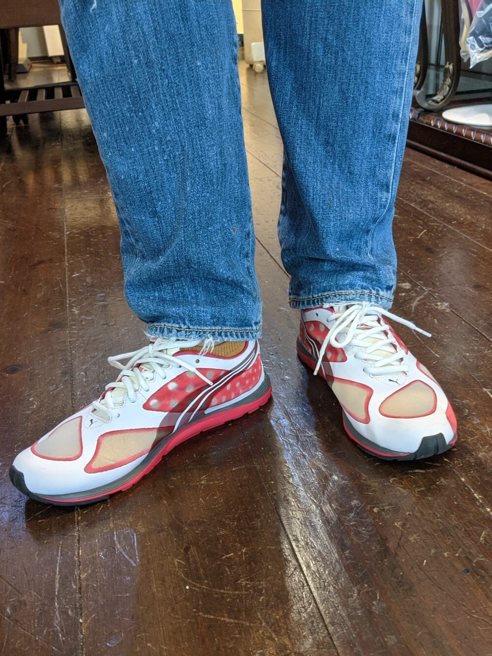 ピンク系のスニーカー、ブルー系のデニムパンツ、イエロー系のサングラスを着用したレディースの夏コーディネートの2枚目の写真