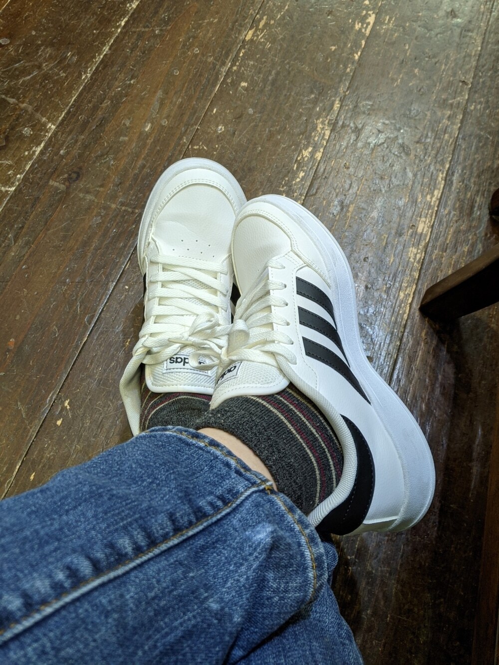 ホワイト系のスニーカー、ブルー系のジャケット/アウター、ブルー系のデニムパンツを着用したレディースの秋コーディネートの3枚目の写真