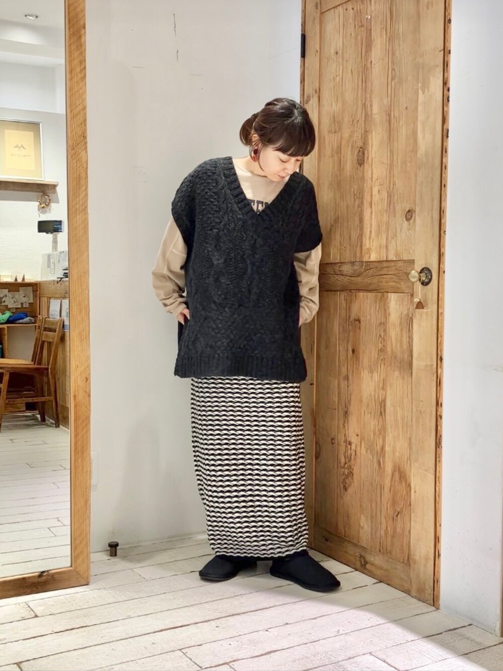 ベージュ系のTシャツ/カットソー、ブラック系のベスト、その他のスカートを着用したレディースの秋コーディネートの2枚目の写真