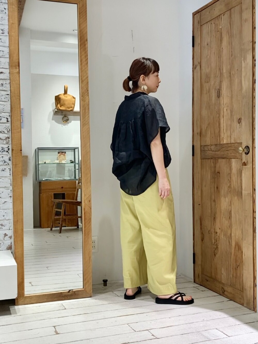 ブラック系のシャツ/ブラウス、イエロー系のその他パンツを着用したレディースの夏コーディネートの2枚目の写真