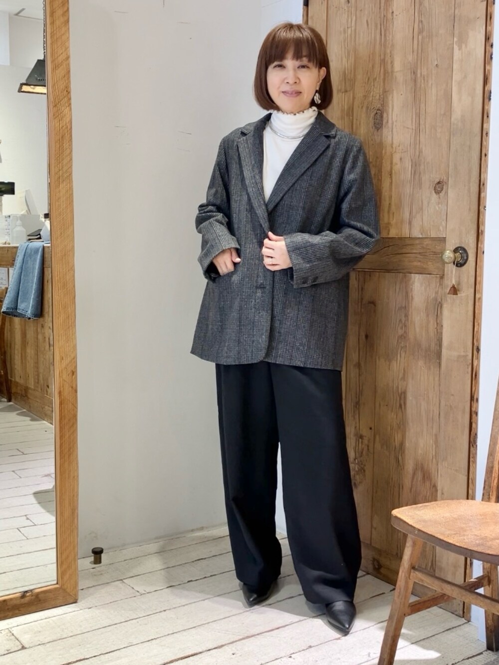 グレー系のテーラードジャケット、ブラック系のスラックスを着用したレディースの秋コーディネートの3枚目の写真