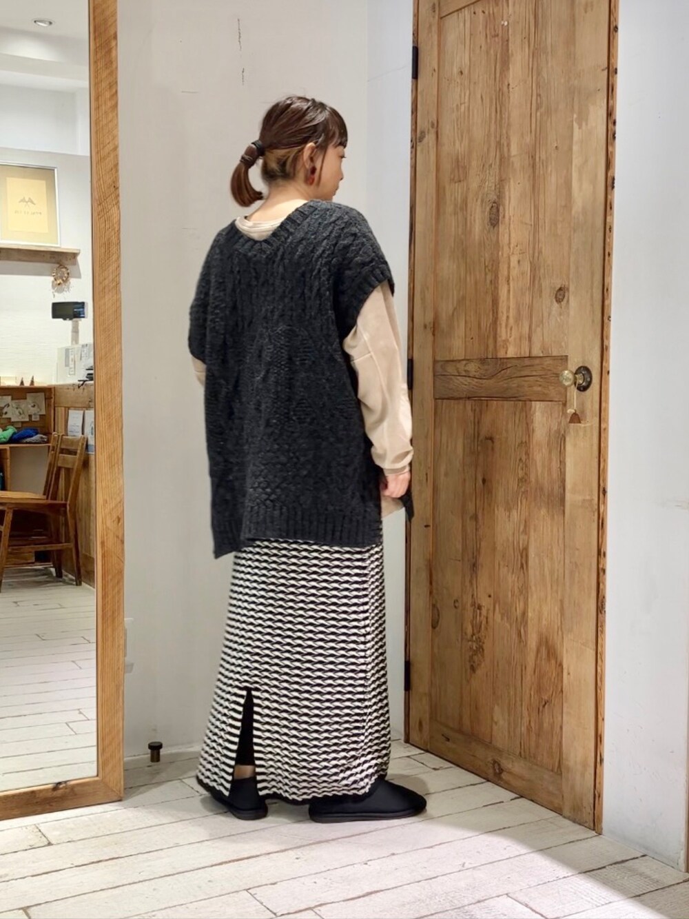 ベージュ系のTシャツ/カットソー、ブラック系のベスト、その他のスカートを着用したレディースの秋コーディネートの4枚目の写真