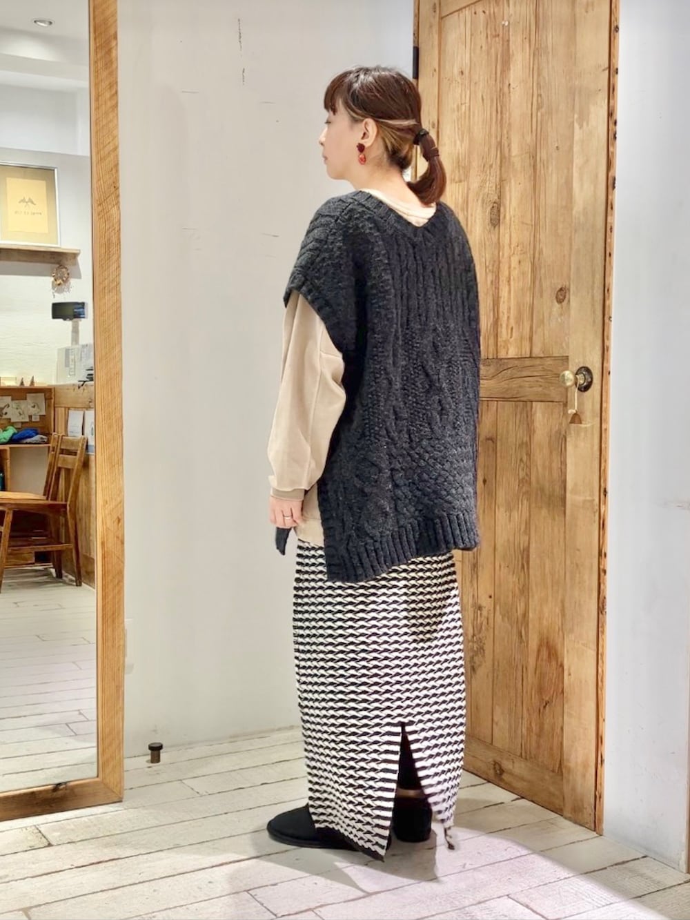 ベージュ系のTシャツ/カットソー、ブラック系のベスト、その他のスカートを着用したレディースの秋コーディネートの3枚目の写真