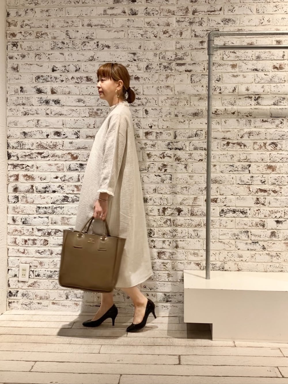 ホワイト系のワンピース、ベージュ系のショルダーバッグを着用したレディースの春コーディネートの4枚目の写真