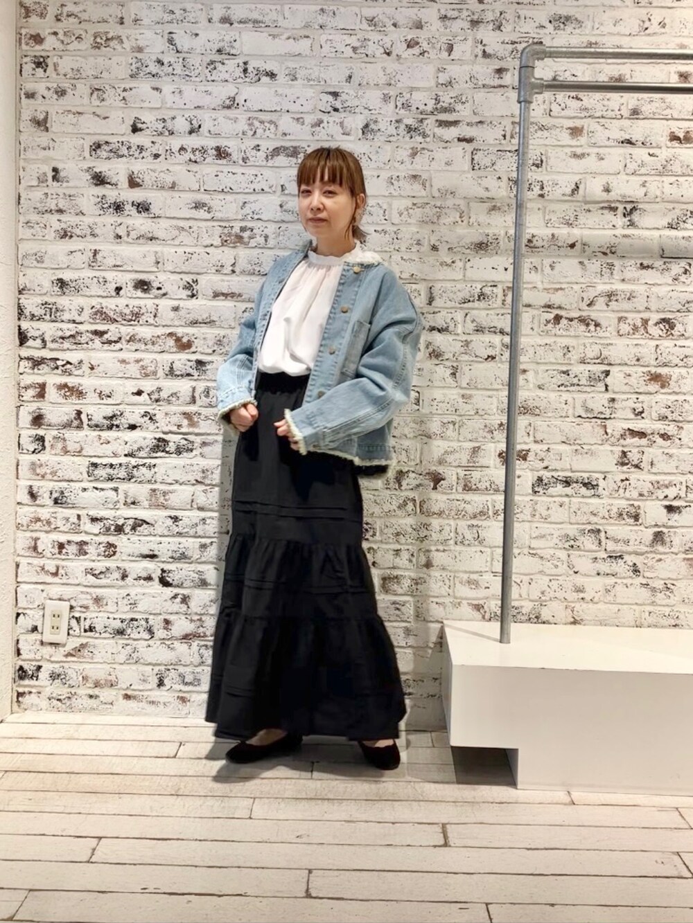 ブルー系のデニムジャケット、ブラック系のスカートを着用したレディースの春コーディネートの8枚目の写真