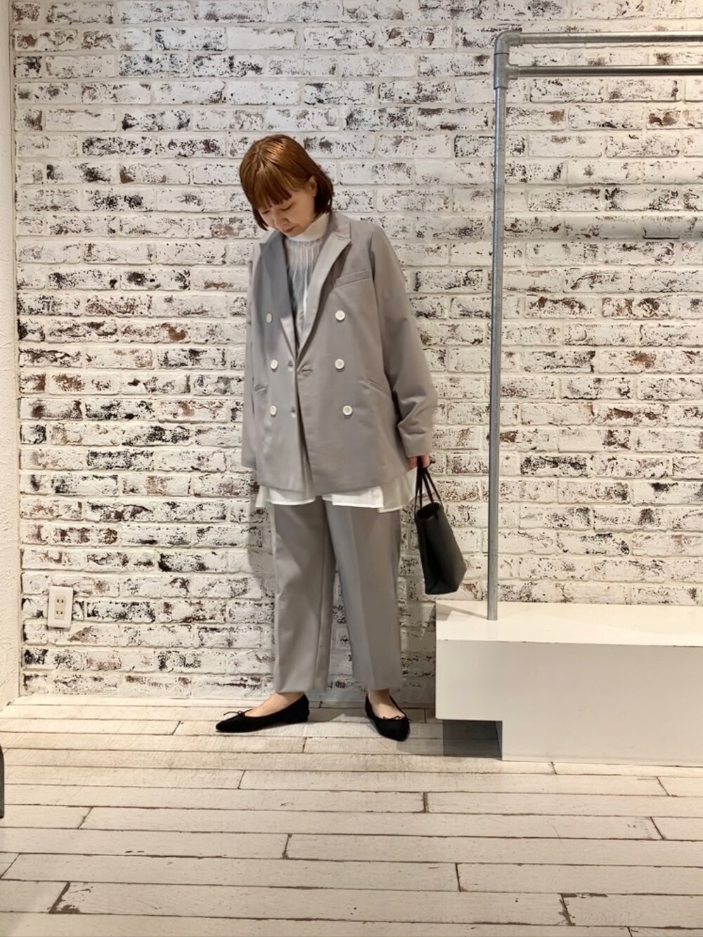 ホワイト系のシャツ/ブラウス、グレー系のテーラードジャケット、ベージュ系のスラックスを着用したレディースの冬コーディネートの2枚目の写真