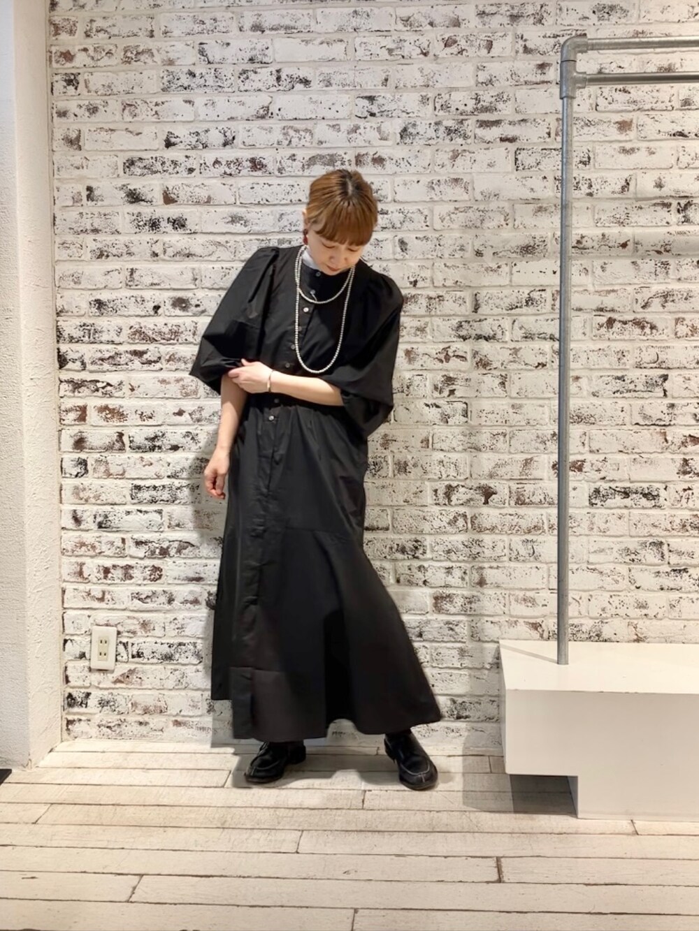 ブラック系のワンピース、グレー系のTシャツ/カットソーを着用したレディースの春コーディネートの2枚目の写真