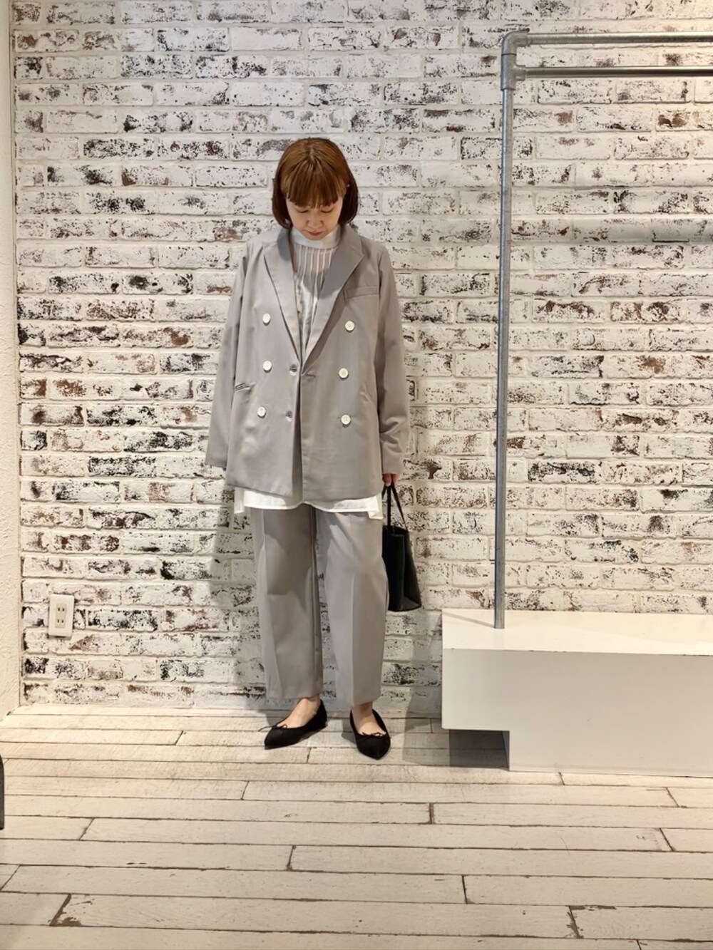 ホワイト系のシャツ/ブラウス、グレー系のテーラードジャケット、ベージュ系のスラックスを着用したレディースの冬コーディネートの4枚目の写真