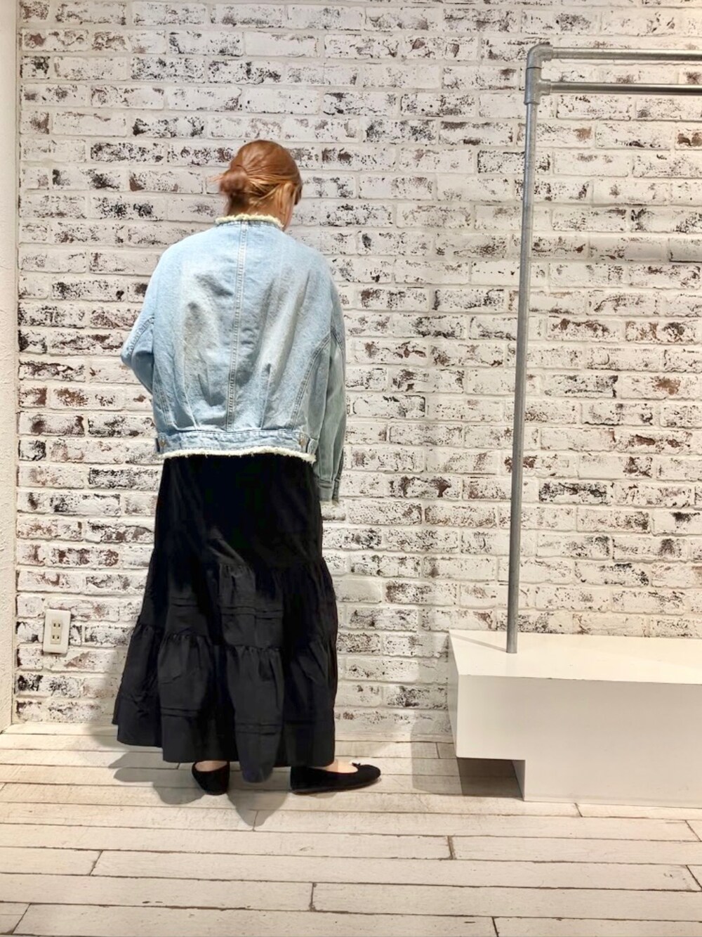 ブルー系のデニムジャケット、ブラック系のスカートを着用したレディースの春コーディネートの4枚目の写真