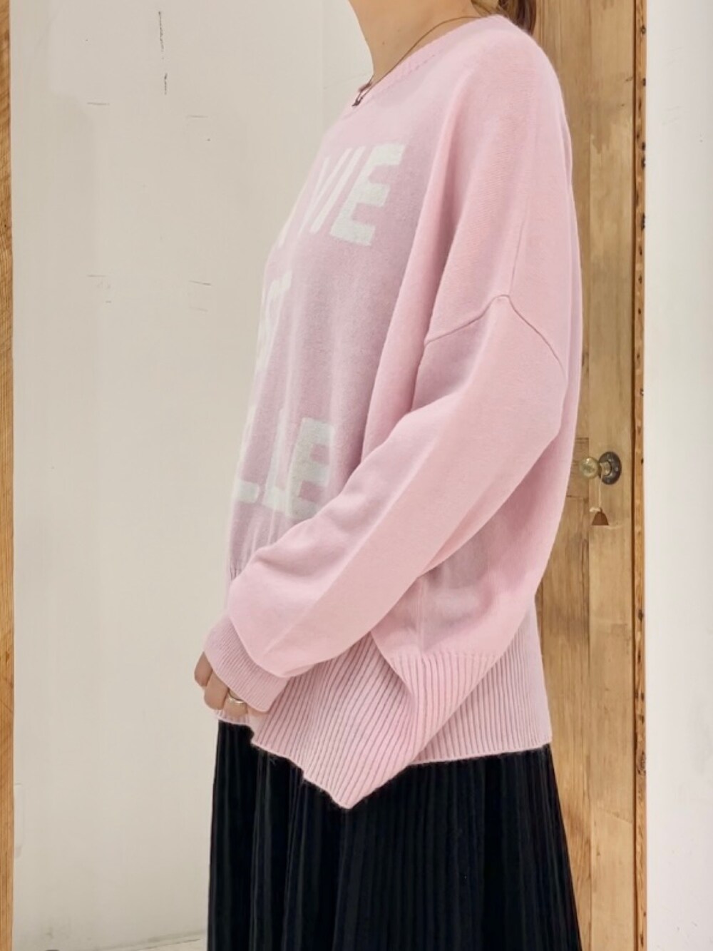 ピンク系のニット/セーター、ブラック系のスカートを着用したレディースの秋コーディネートの5枚目の写真