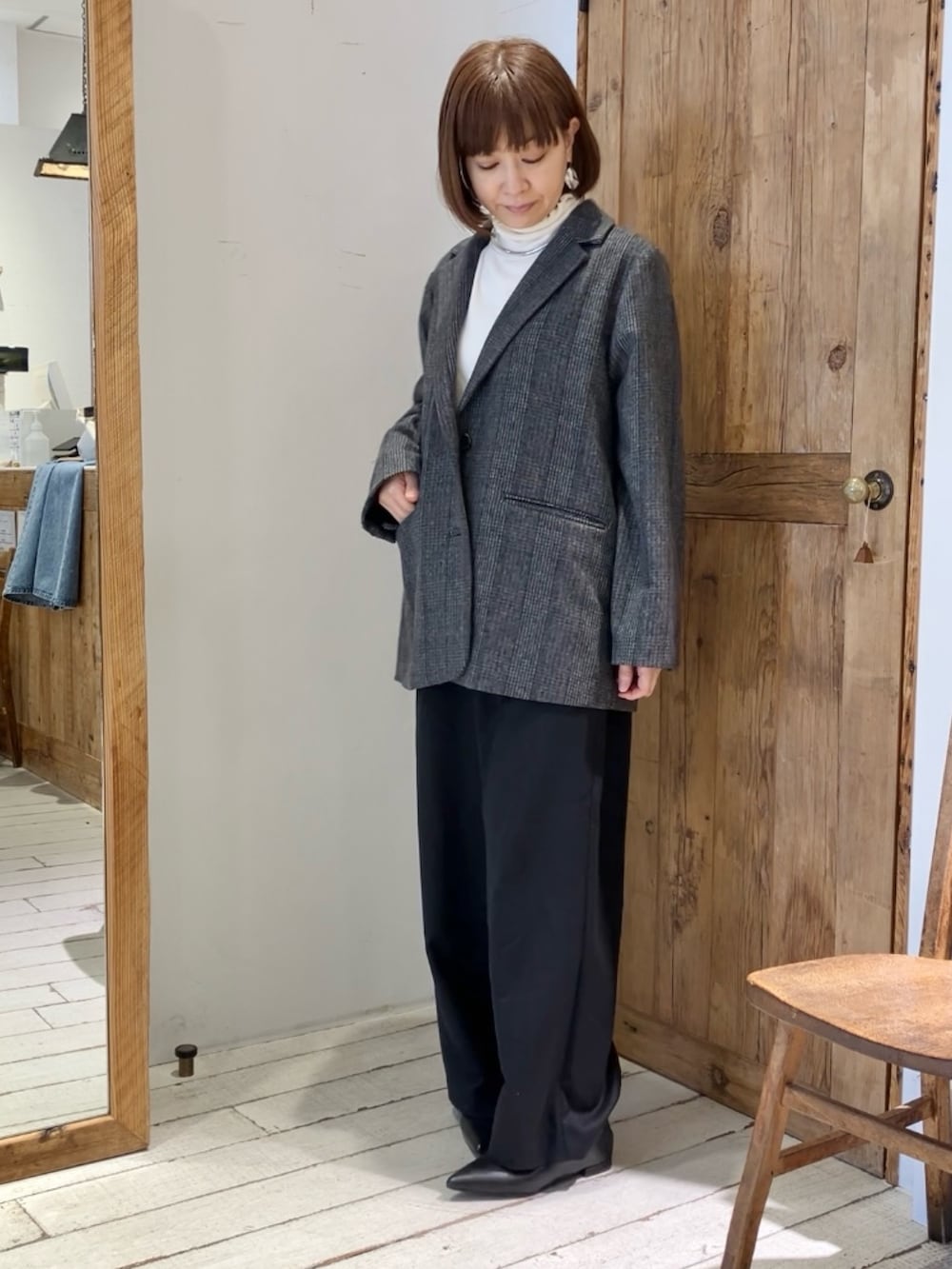 グレー系のテーラードジャケット、ブラック系のスラックスを着用したレディースの秋コーディネートの2枚目の写真