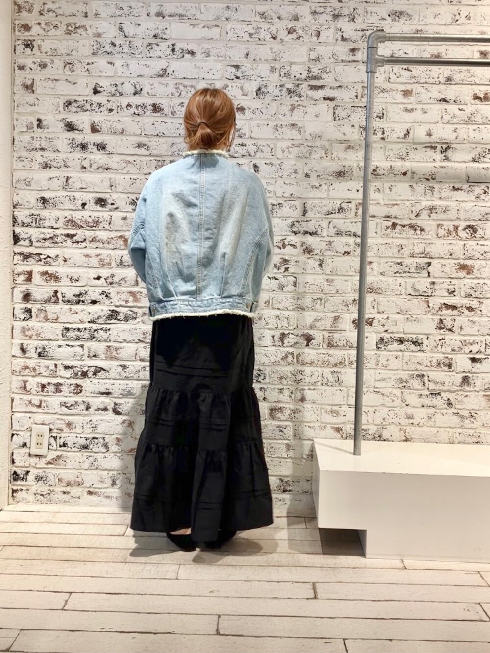 ブルー系のデニムジャケット、ブラック系のスカートを着用したレディースの春コーディネートの7枚目の写真