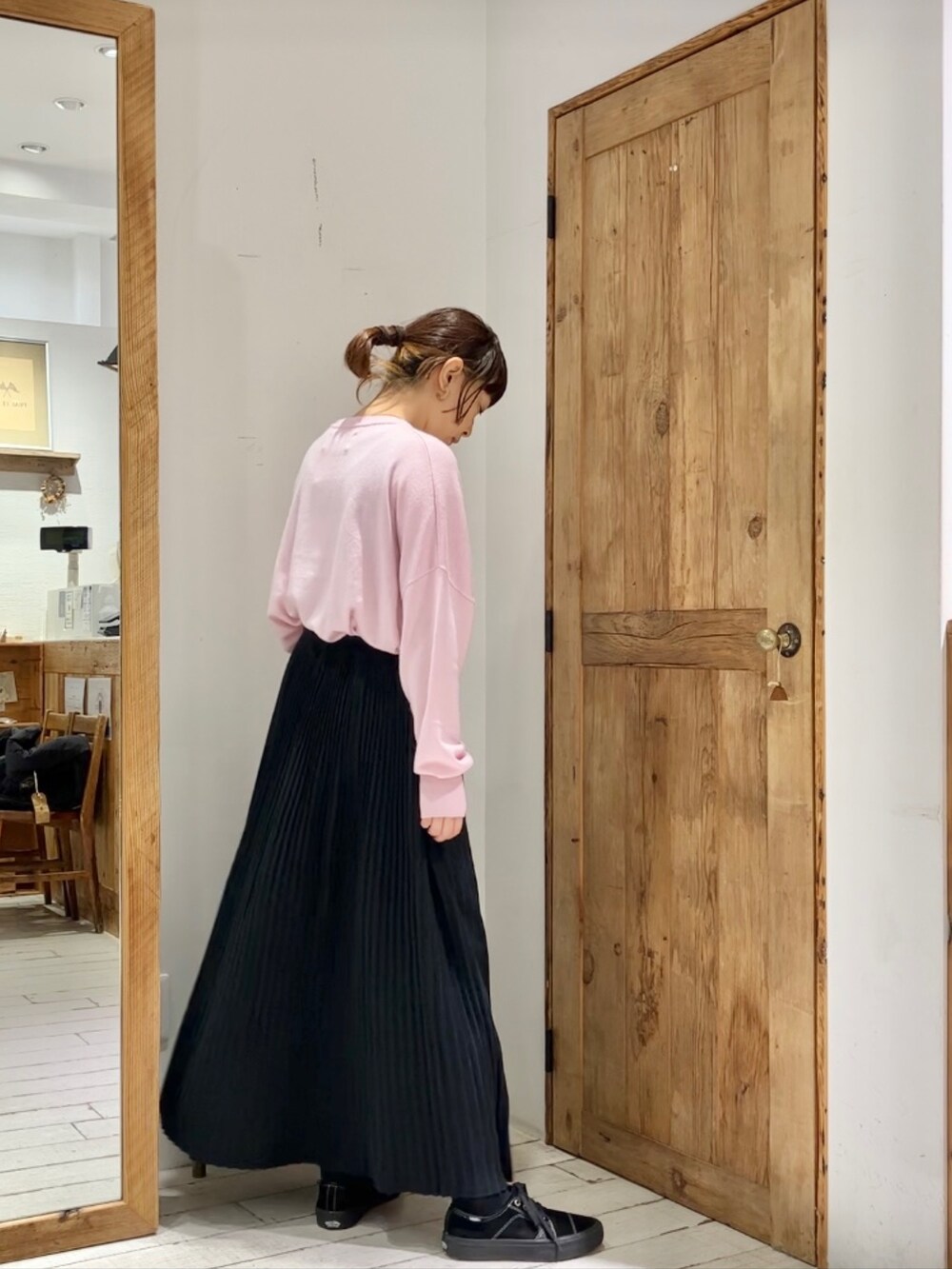 ピンク系のニット/セーター、ブラック系のスカートを着用したレディースの秋コーディネートの3枚目の写真
