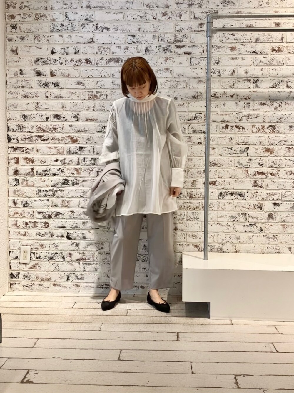 ホワイト系のシャツ/ブラウス、グレー系のテーラードジャケット、ベージュ系のスラックスを着用したレディースの冬コーディネートの5枚目の写真