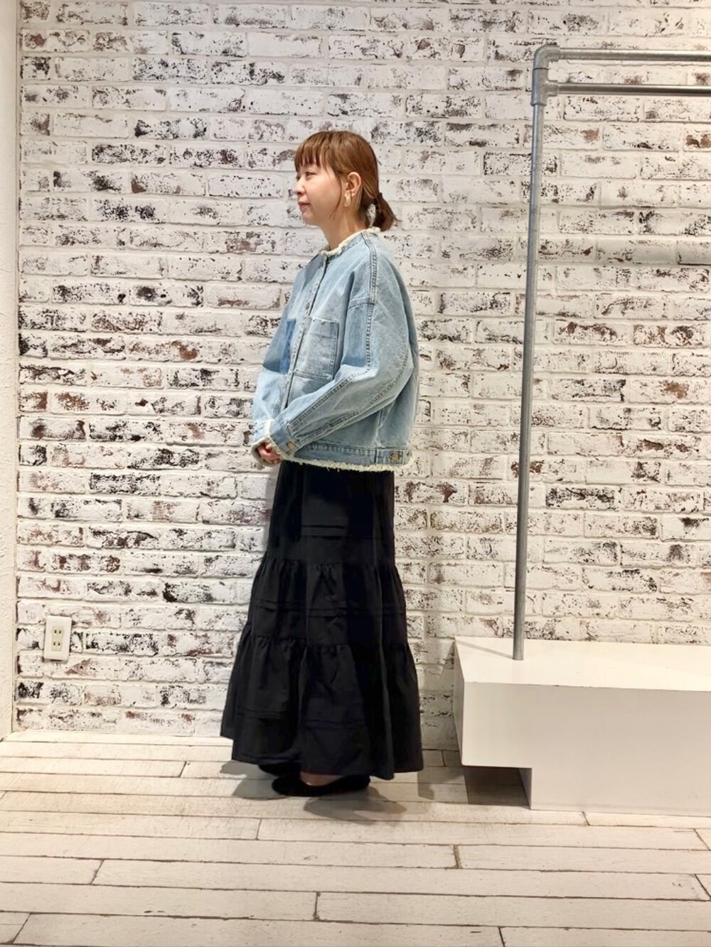 ブルー系のデニムジャケット、ブラック系のスカートを着用したレディースの春コーディネートの6枚目の写真