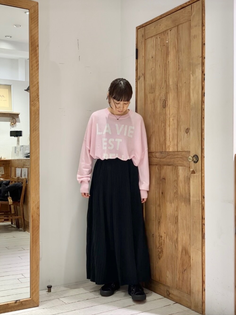 ピンク系のニット/セーター、ブラック系のスカートを着用したレディースの秋コーディネートの2枚目の写真