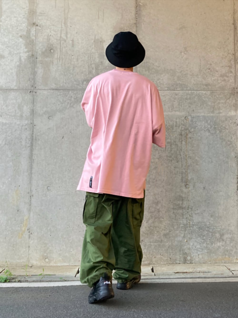 グリーン系のカーゴパンツ、ブラック系のスニーカー、ピンク系のTシャツ/カットソーを着用したメンズの夏コーディネートの2枚目の写真