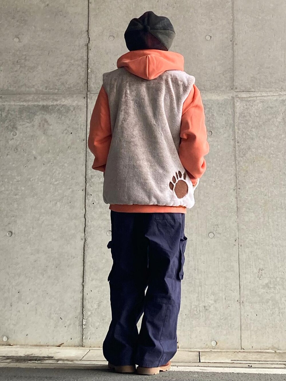 ブルー系のパンツ、ブラウン系のブーツ、ベージュ系のベストを着用したメンズの冬コーディネートの2枚目の写真