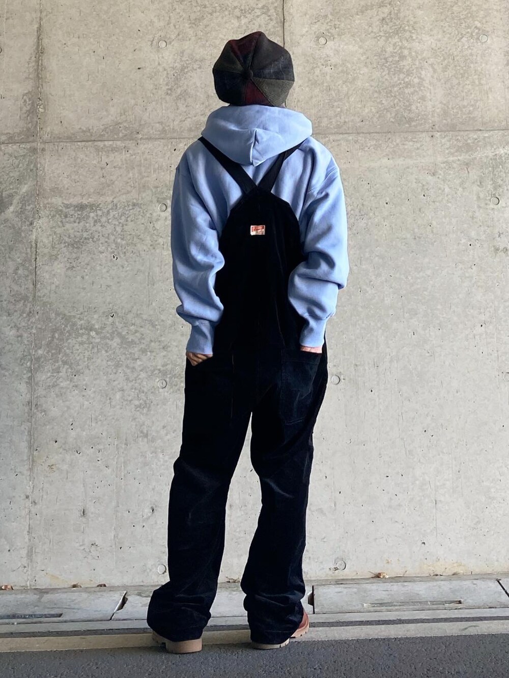 ブラウン系のブーツ、ブラック系のサロペット/オーバーオール、ブルー系のパーカーを着用したメンズの冬コーディネートの2枚目の写真