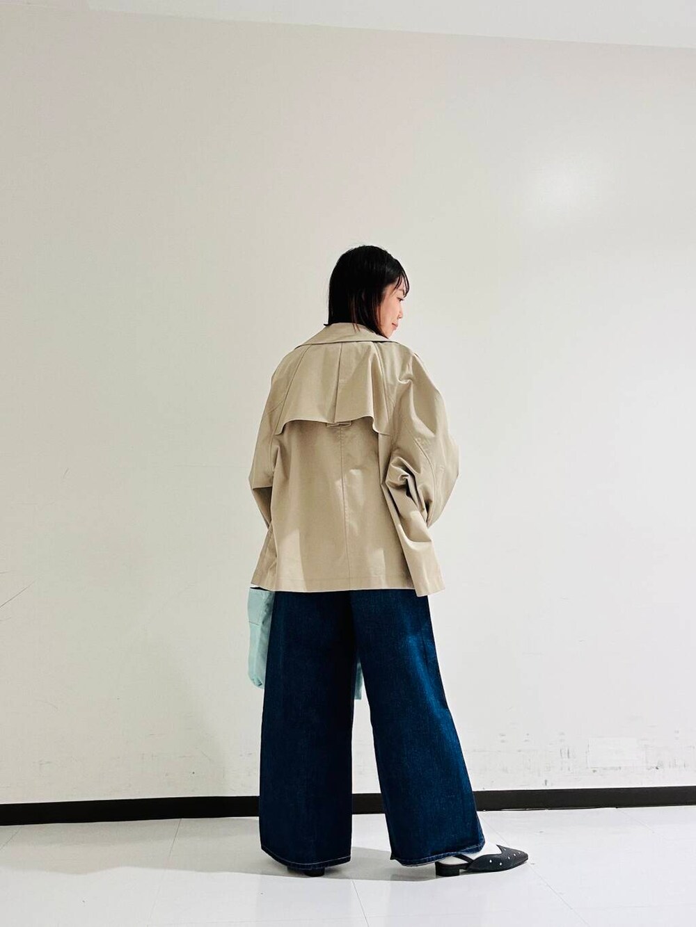 ベージュ系のトレンチコート、ブラック系のパンプス、レッド系のニット/セーターを着用したレディースの春コーディネートの3枚目の写真