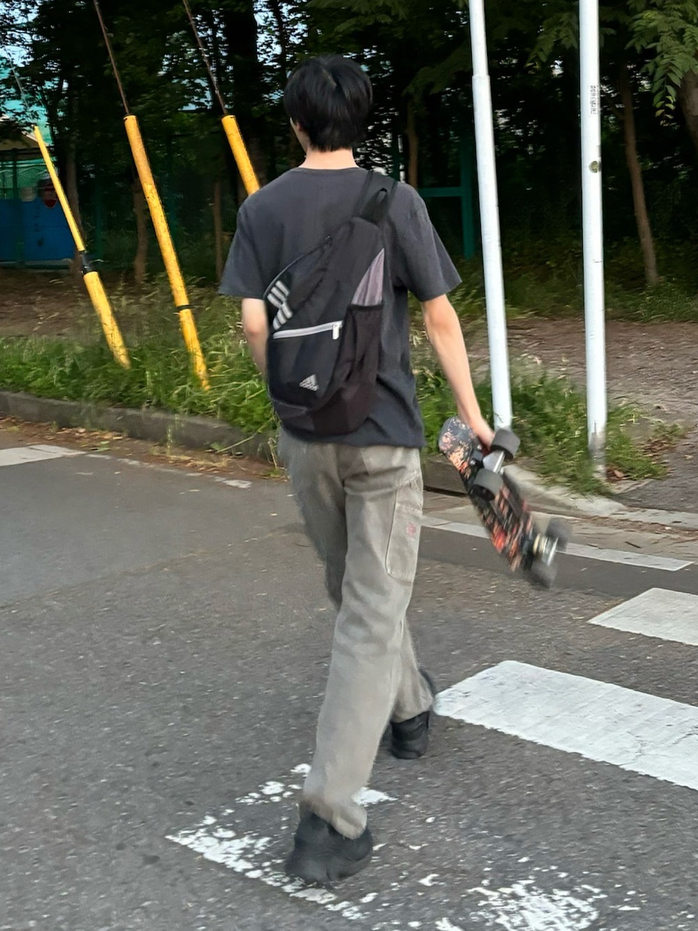 グレー系のデニムパンツ、ブラック系のTシャツ/カットソー、ブラック系のスニーカーを着用したメンズの春コーディネートの2枚目の写真