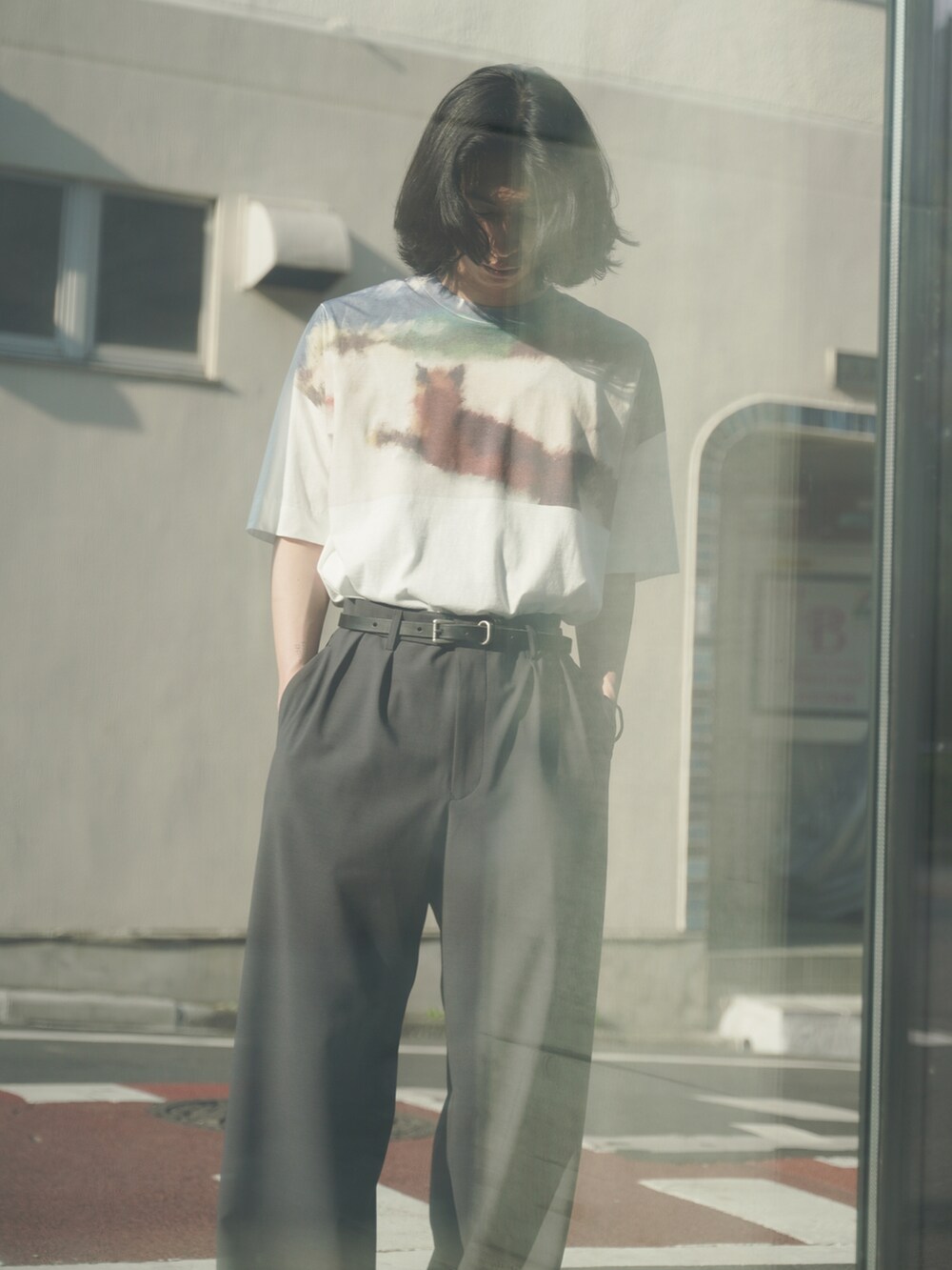 ホワイト系のTシャツ/カットソー、グレー系のスラックス、ブラック系のシューズを着用したメンズの夏コーディネートの4枚目の写真
