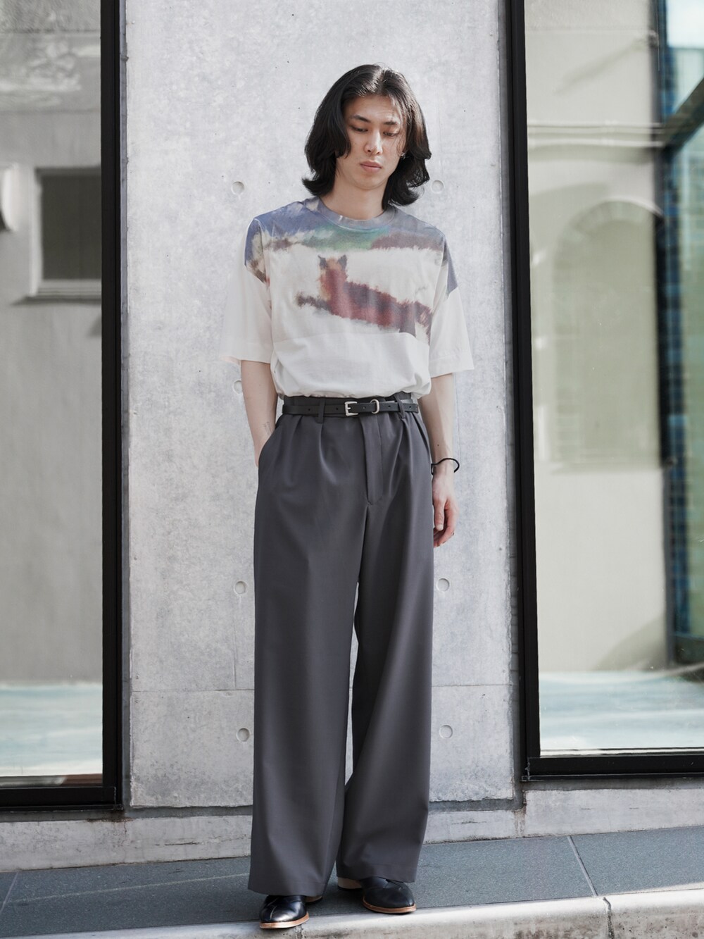 ホワイト系のTシャツ/カットソー、グレー系のスラックス、ブラック系のシューズを着用したメンズの夏コーディネートの5枚目の写真