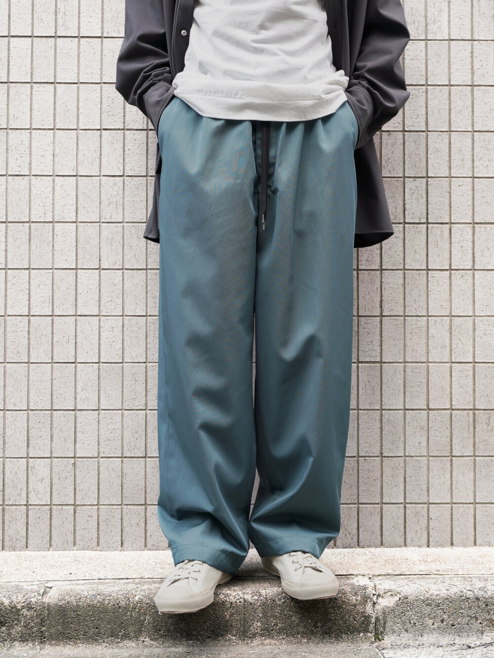 グレー系のシャツ/ブラウス、ホワイト系のTシャツ/カットソー、グリーン系のスラックスを着用したメンズの春コーディネートの4枚目の写真