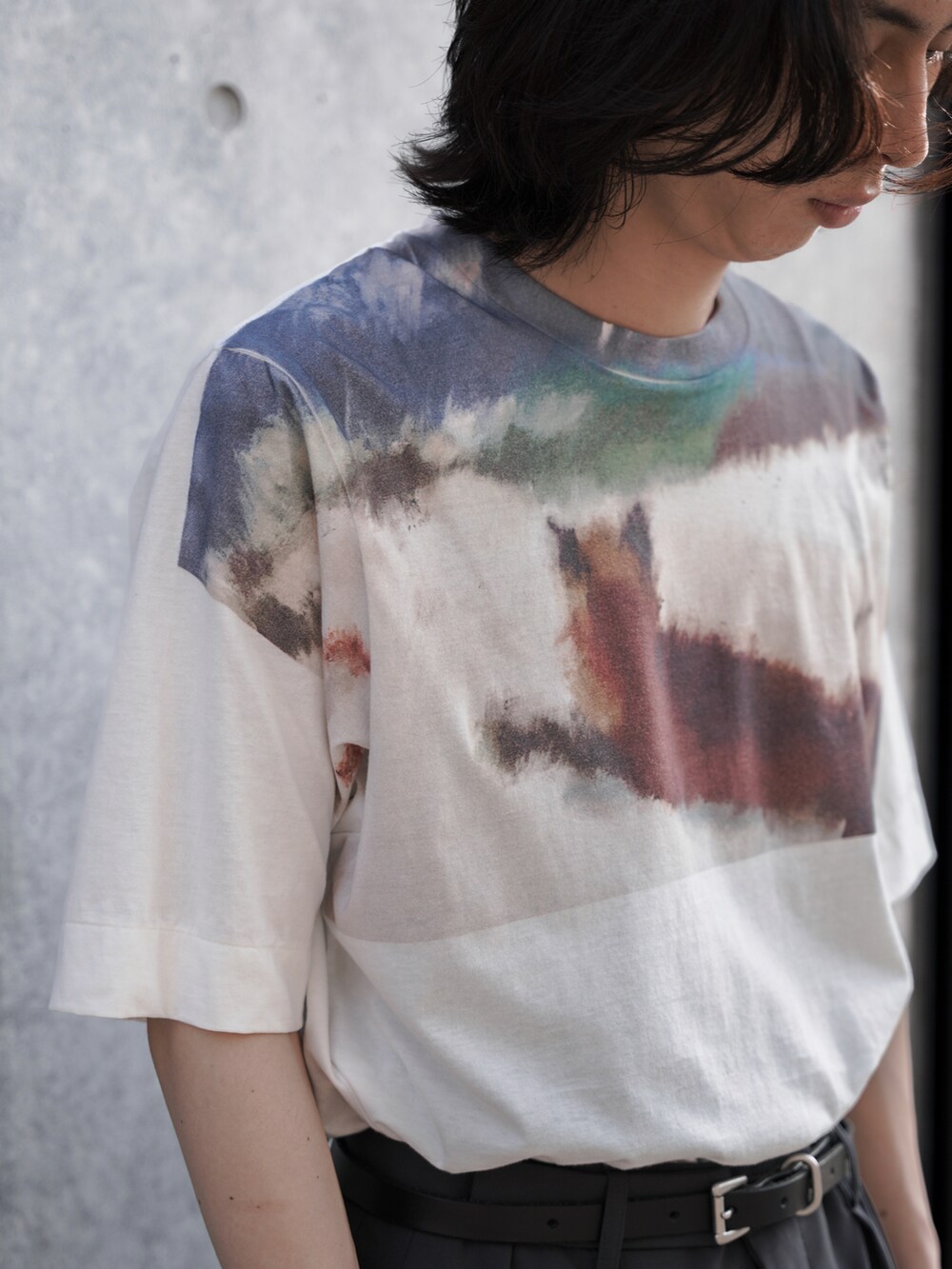 ホワイト系のTシャツ/カットソー、グレー系のスラックス、ブラック系のシューズを着用したメンズの夏コーディネートの2枚目の写真