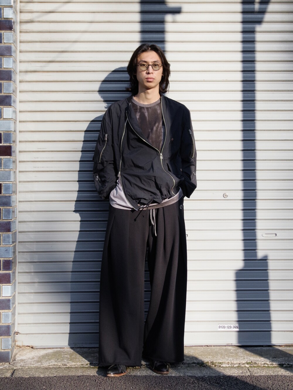 ブラック系のMA-1、ブラック系のTシャツ/カットソー、ブラック系のスウェットパンツを着用したメンズの冬コーディネートの5枚目の写真