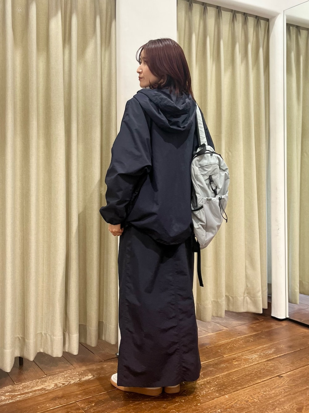 ブルー系のナイロンジャケット、ブルー系のスカート、パープル系のTシャツ/カットソーを着用したレディースの冬コーディネートの3枚目の写真