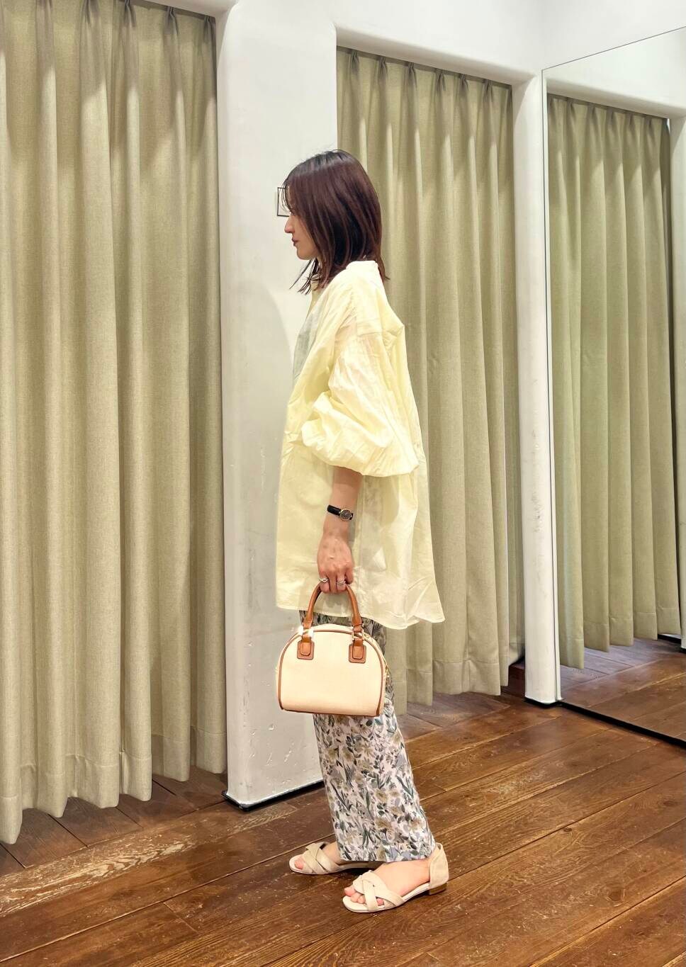 イエロー系のボストンバッグ、ベージュ系のその他パンツ、ベージュ系のサンダルを着用したレディースの春コーディネートの2枚目の写真