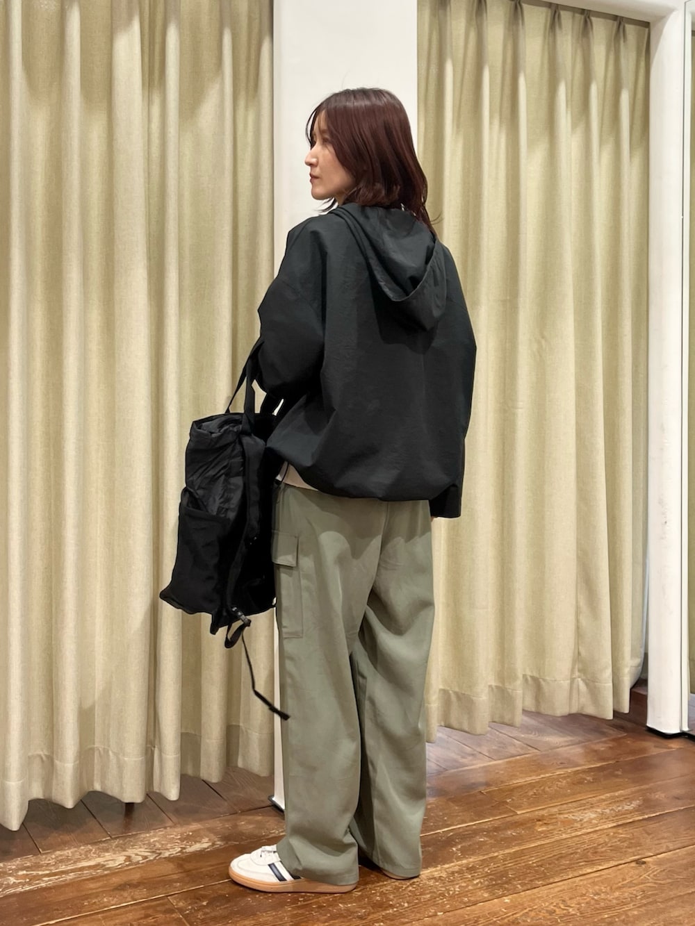 ブラック系のその他アウター、グレー系のニット/セーター、グリーン系のその他パンツを着用したレディースの春コーディネートの2枚目の写真