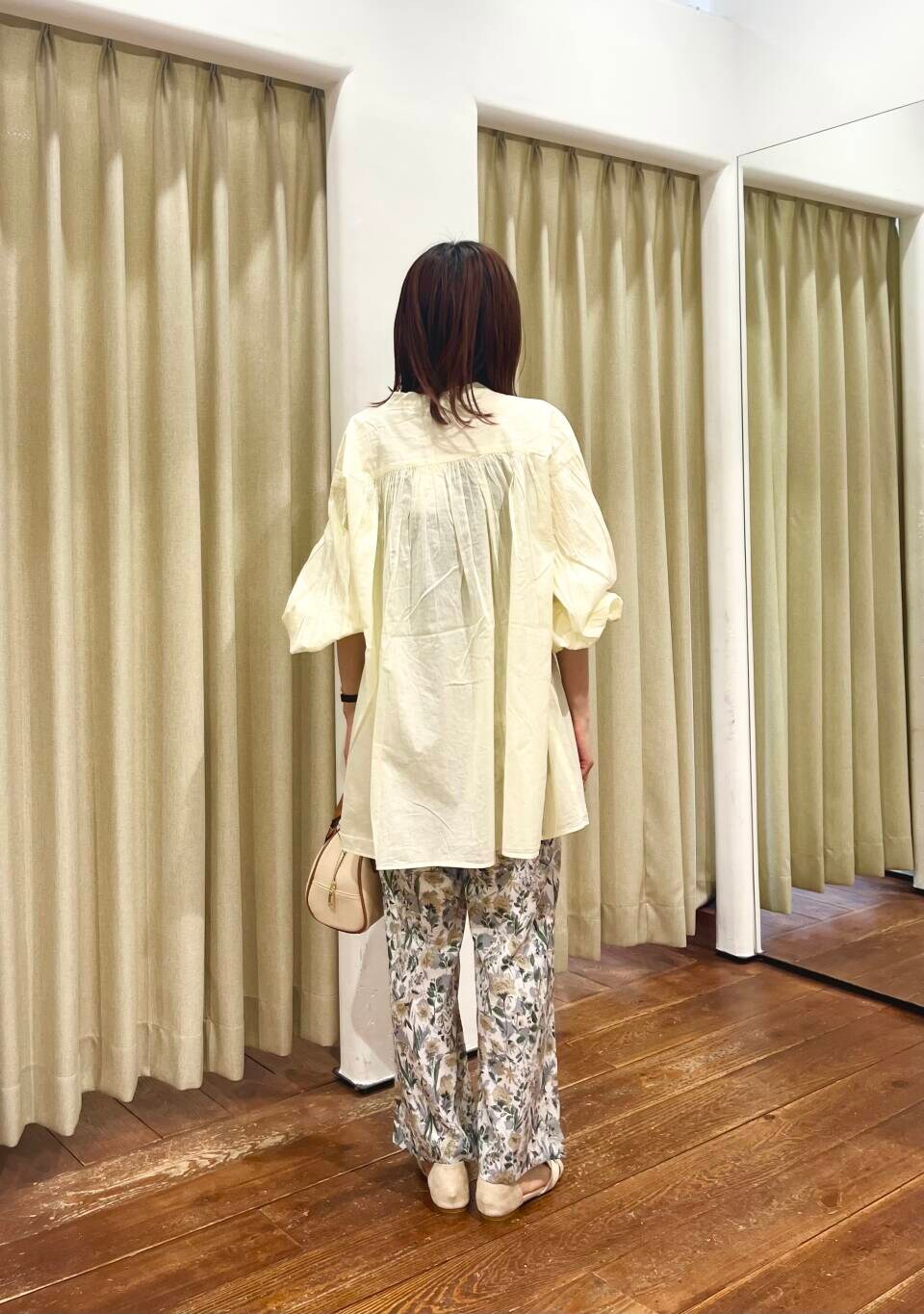 イエロー系のボストンバッグ、ベージュ系のその他パンツ、ベージュ系のサンダルを着用したレディースの春コーディネートの3枚目の写真