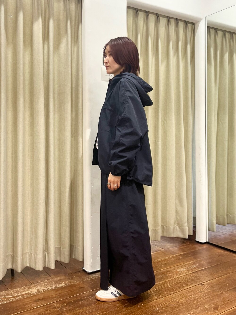 ブルー系のナイロンジャケット、ブルー系のスカート、パープル系のTシャツ/カットソーを着用したレディースの冬コーディネートの2枚目の写真