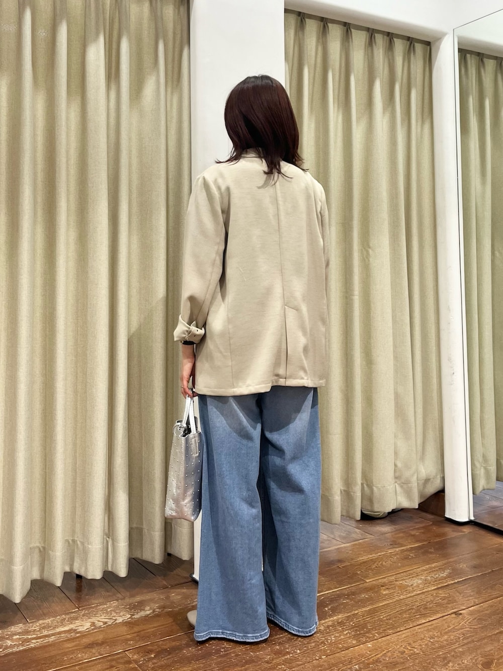 ベージュ系のその他アウター、ブルー系のデニムパンツ、ベージュ系のパンプスを着用したレディースの春コーディネートの4枚目の写真