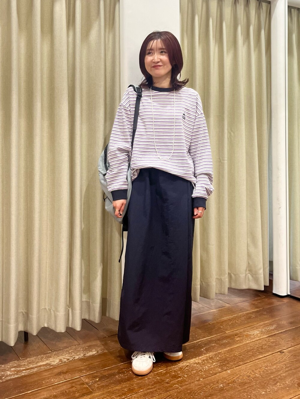 ブルー系のナイロンジャケット、ブルー系のスカート、パープル系のTシャツ/カットソーを着用したレディースの冬コーディネートの5枚目の写真