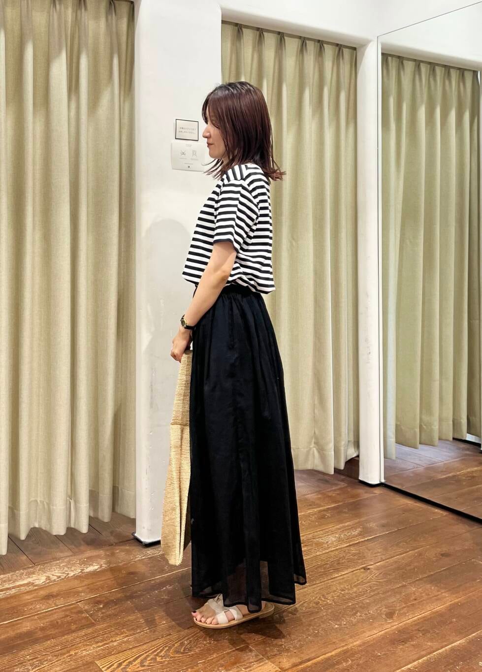 ブラック系のタンクトップ、ホワイト系のサンダル、ブラック系のワンピースを着用したレディースの夏コーディネートの3枚目の写真