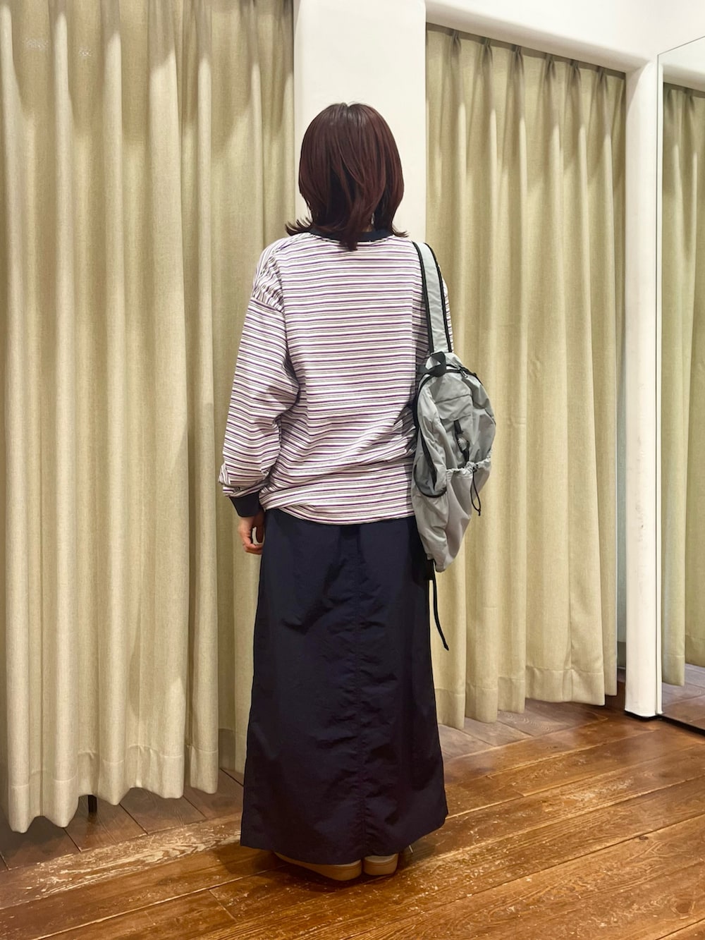 ブルー系のナイロンジャケット、ブルー系のスカート、パープル系のTシャツ/カットソーを着用したレディースの冬コーディネートの7枚目の写真