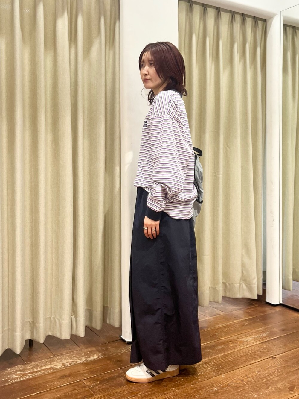 ブルー系のナイロンジャケット、ブルー系のスカート、パープル系のTシャツ/カットソーを着用したレディースの冬コーディネートの6枚目の写真