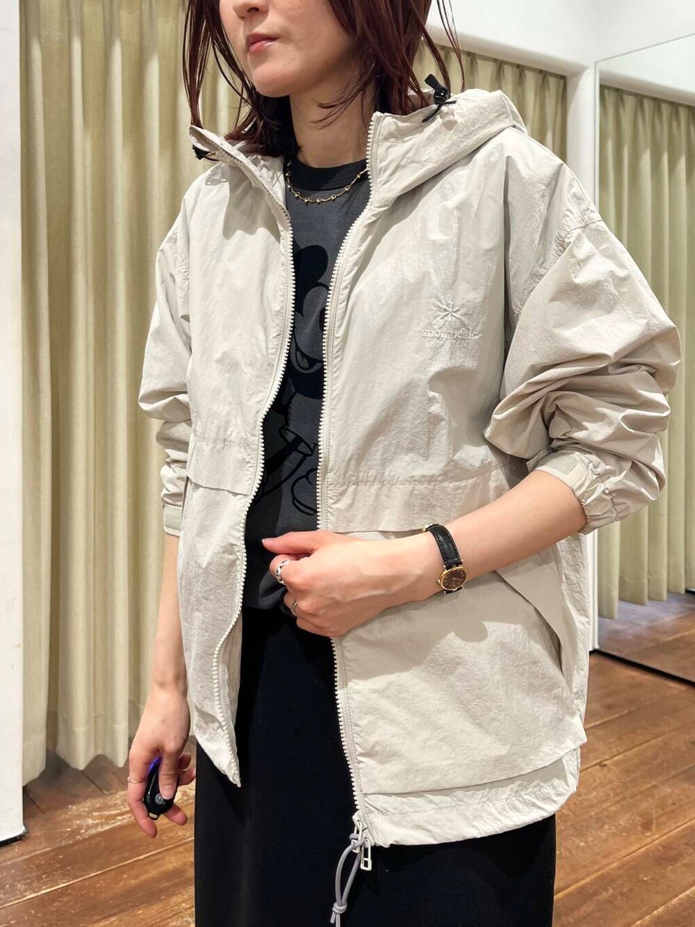ブラック系のTシャツ/カットソー、ホワイト系のナイロンジャケット、ブラック系のスカートを着用したレディースの春コーディネートの3枚目の写真