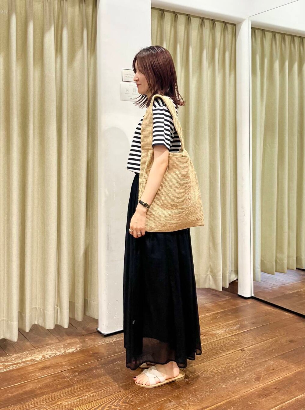 ブラック系のタンクトップ、ホワイト系のサンダル、ブラック系のワンピースを着用したレディースの夏コーディネートの2枚目の写真